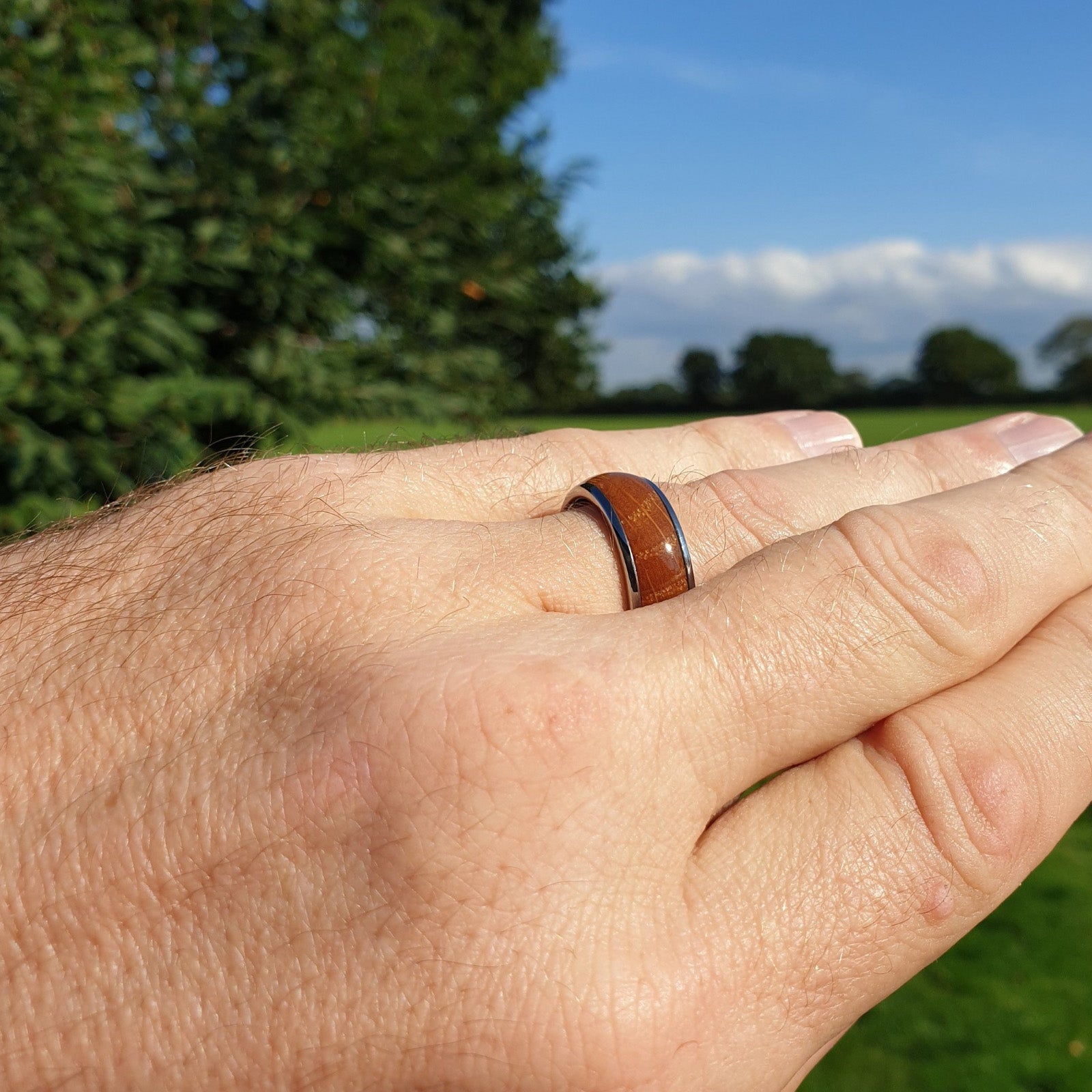 Top view of Shiny wood inlay rock solid ring on man's finger