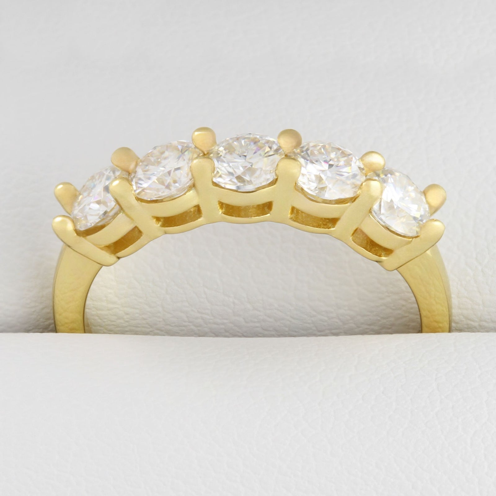 Detailed close up of 1.5ct moissanite five-stone gold ring in its ring box.