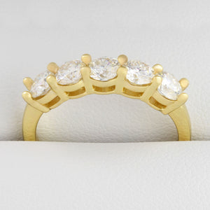 Detailed close up of 1.5ct moissanite five-stone gold ring in its ring box.