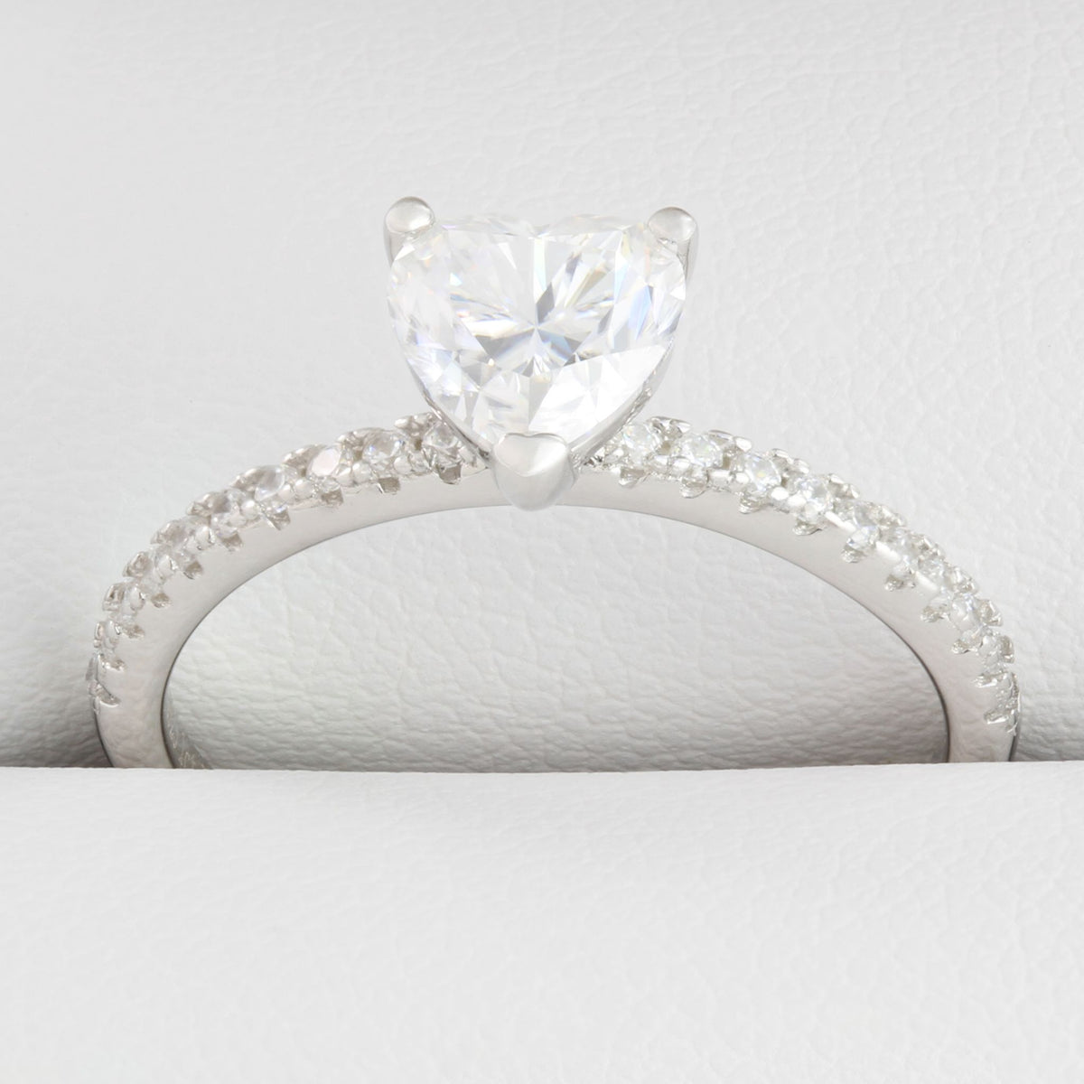 Close-up of heart-shaped moissanite centre stone with small round stones in white gold ring