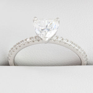 Close-up of heart-shaped moissanite centre stone with small round stones in white gold ring