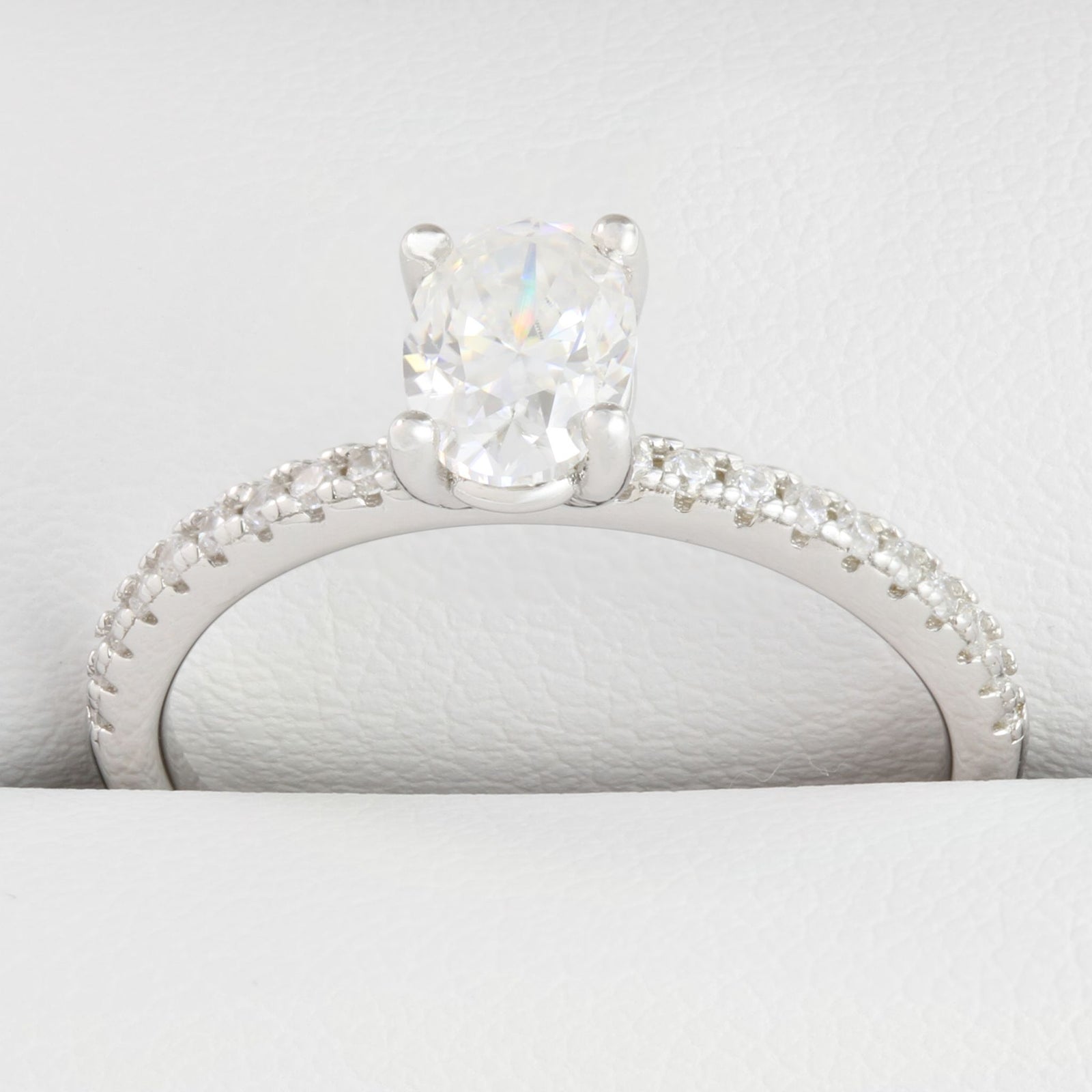 Close-up of oval-shaped moissanite centre stone with small round stones in white gold ring