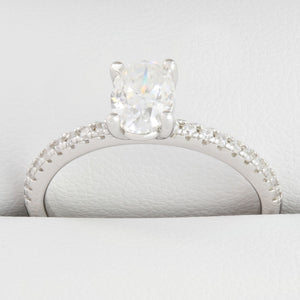 Close-up of oval-shaped moissanite centre stone with small round stones in white gold ring