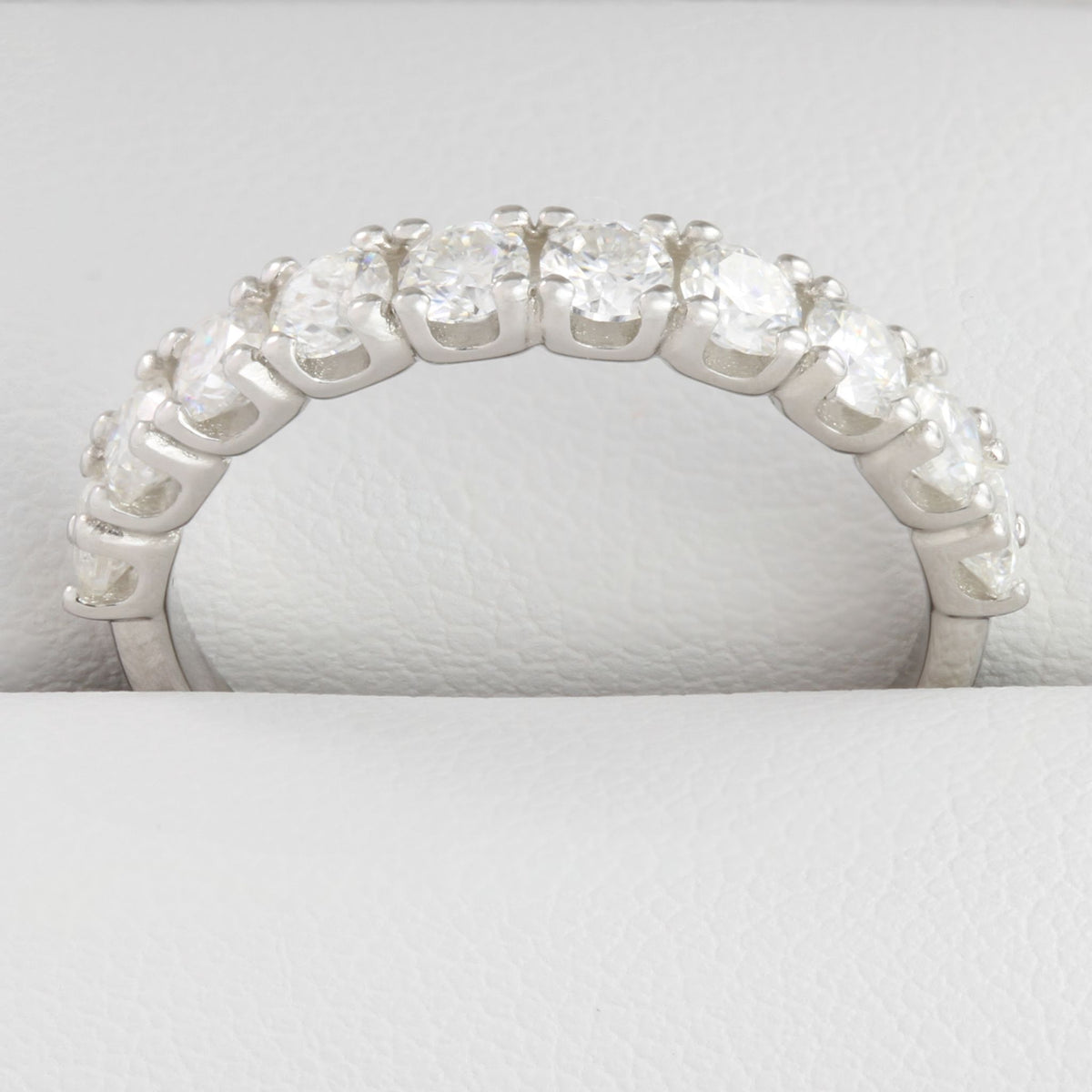 Close-up of round moissanite stones in white gold half eternity ring