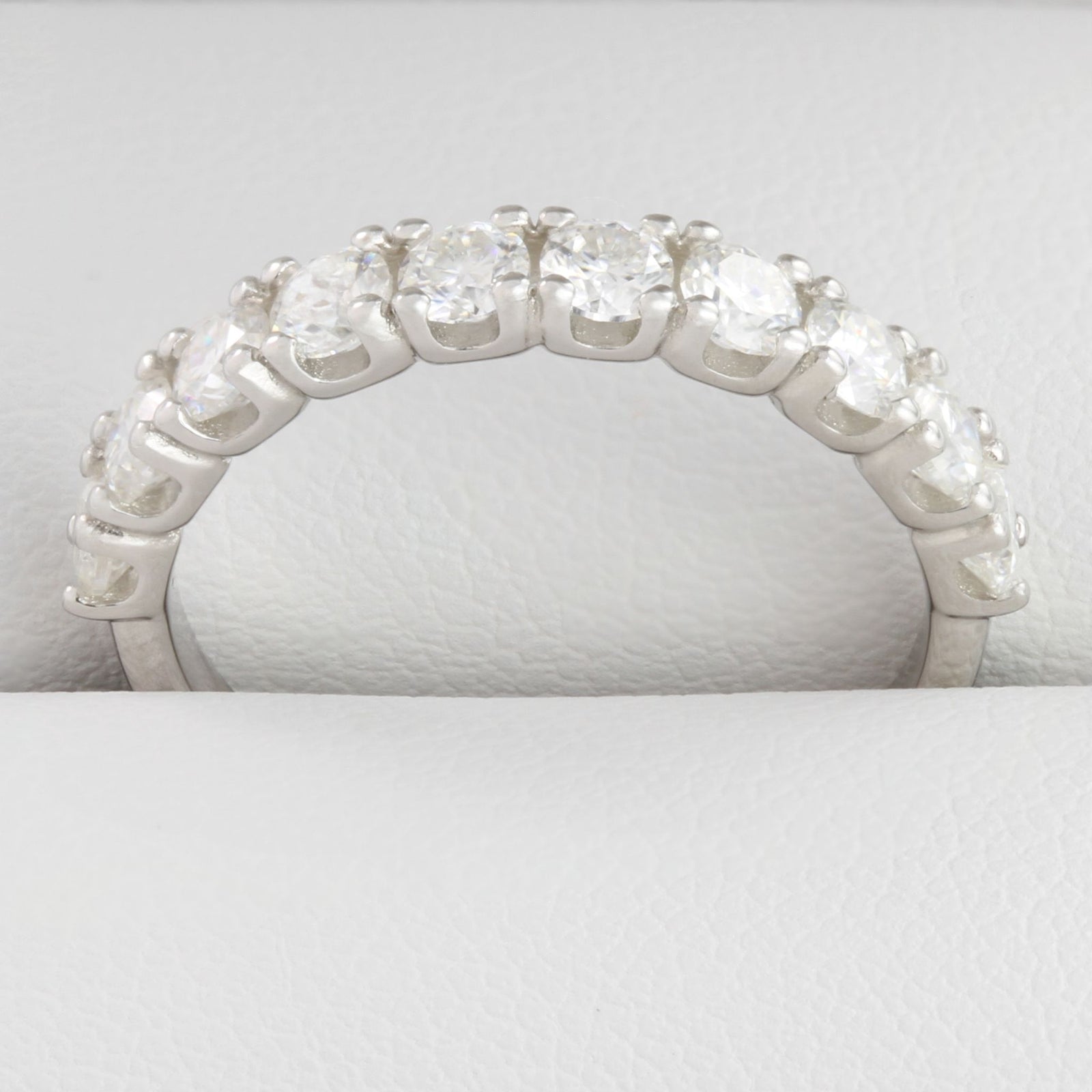 Close-up of round moissanite stones in white gold half eternity ring
